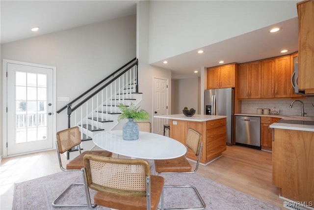 dining room with recessed lighting, stairway, high vaulted ceiling, and light wood finished floors