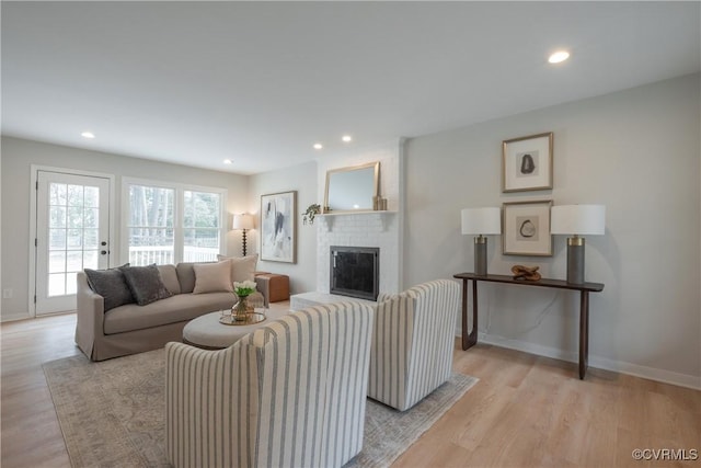 living room with recessed lighting, light wood-type flooring, and baseboards