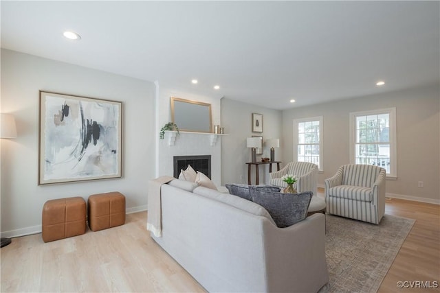 living room featuring recessed lighting, baseboards, wood finished floors, and a fireplace