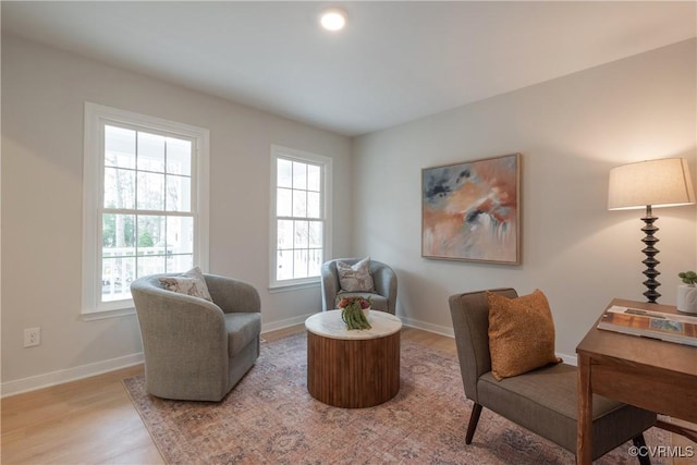 living area featuring baseboards and light wood-style floors