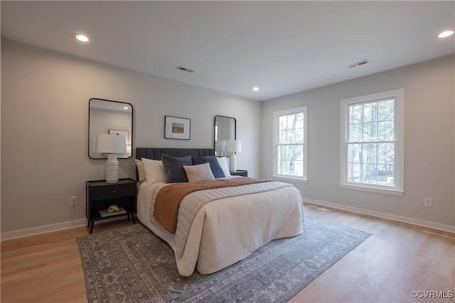 bedroom featuring light wood-type flooring, visible vents, baseboards, and recessed lighting