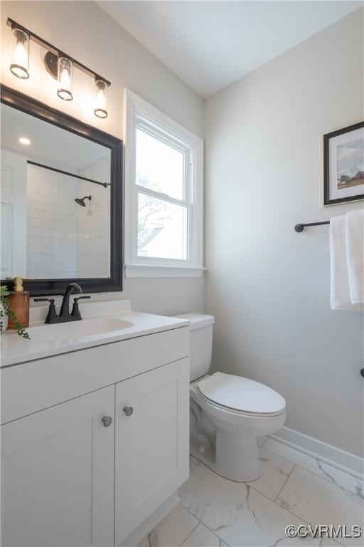 bathroom with toilet, marble finish floor, baseboards, walk in shower, and vanity