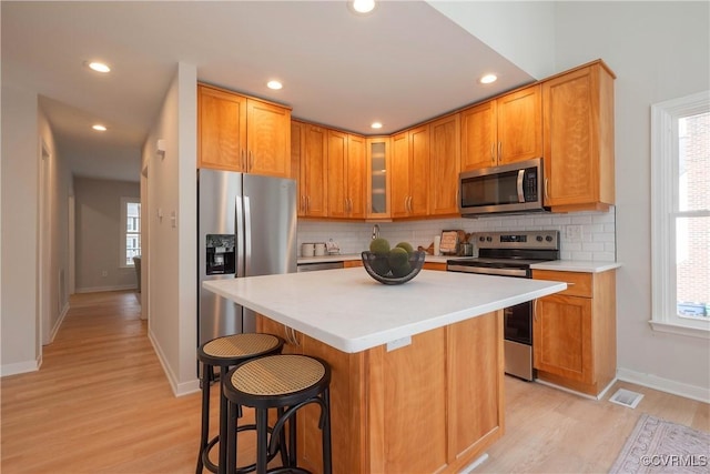 kitchen with a wealth of natural light, visible vents, appliances with stainless steel finishes, and light countertops