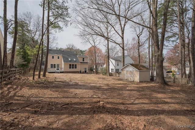 view of yard featuring an outbuilding, fence, and a shed