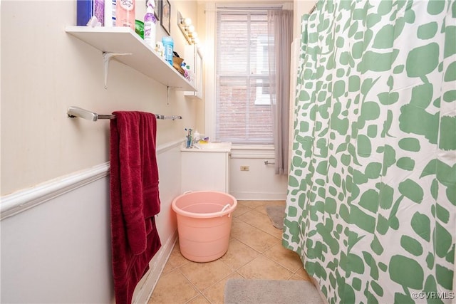 full bath featuring tile patterned floors, a shower with shower curtain, and baseboards