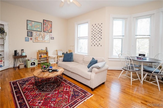 living area with hardwood / wood-style floors, baseboards, and ceiling fan