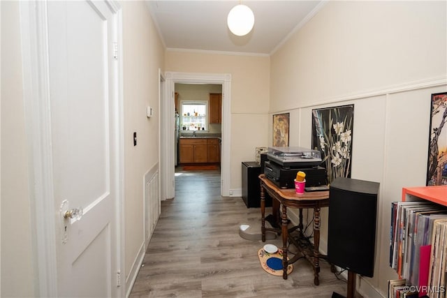 hall featuring crown molding, visible vents, and light wood-type flooring