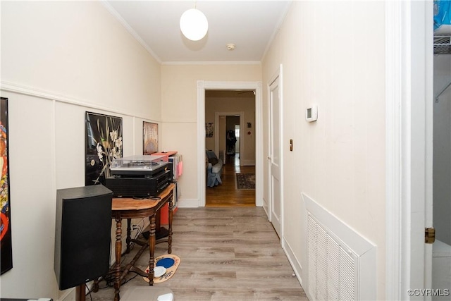 office with light wood-type flooring, visible vents, and ornamental molding