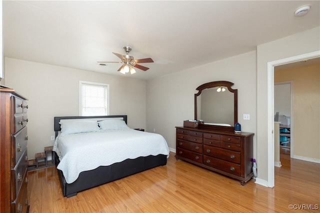 bedroom featuring baseboards, light wood-type flooring, and ceiling fan