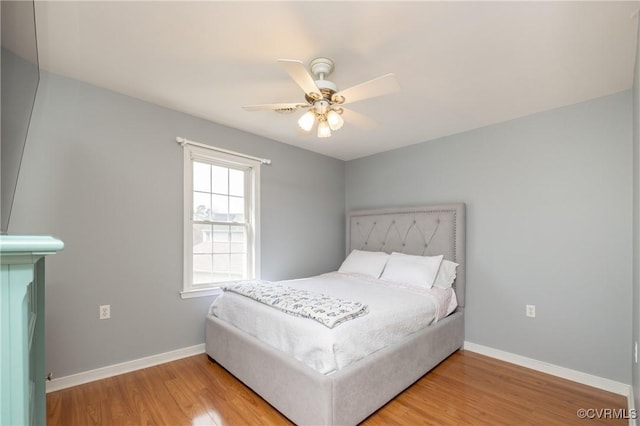 bedroom featuring ceiling fan, baseboards, and wood finished floors