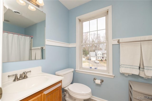 full bath with visible vents, plenty of natural light, vanity, and toilet