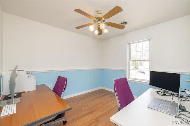 office with ceiling fan, visible vents, baseboards, and wood finished floors