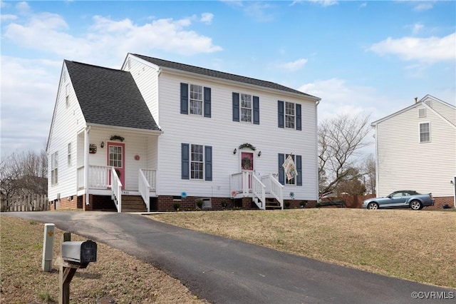 colonial inspired home with crawl space, driveway, a front yard, and roof with shingles