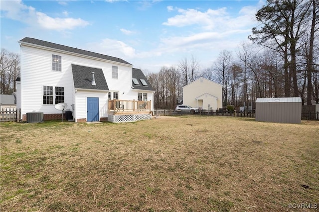 back of house with an outbuilding, a deck, a yard, and fence