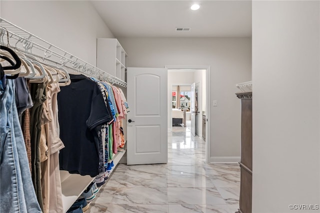 spacious closet with light marble finish floors