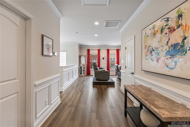 hallway with dark wood finished floors, crown molding, a decorative wall, and visible vents