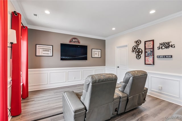 cinema featuring wood finished floors, crown molding, a wainscoted wall, and recessed lighting