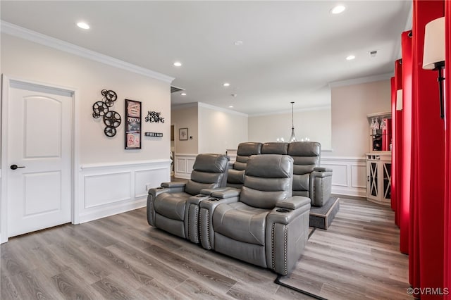 cinema with recessed lighting, ornamental molding, a wainscoted wall, and wood finished floors
