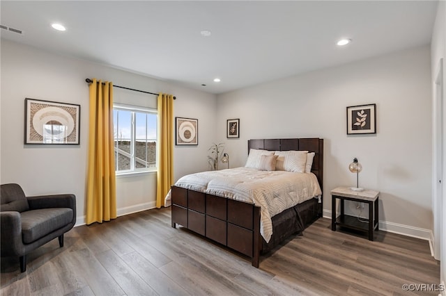 bedroom with dark wood-type flooring, baseboards, and recessed lighting