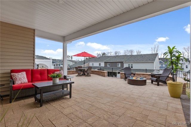view of patio with a residential view, an outdoor living space with a fire pit, and outdoor dining area