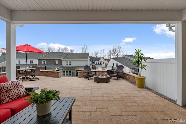 view of patio featuring outdoor dining space, an outdoor living space with a fire pit, and a residential view