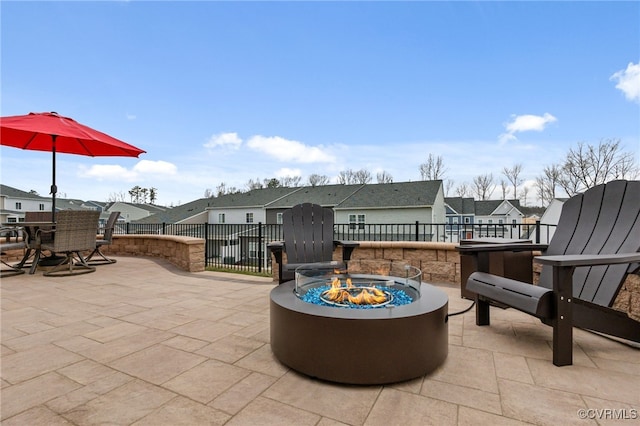 view of patio featuring a fire pit, a residential view, and fence
