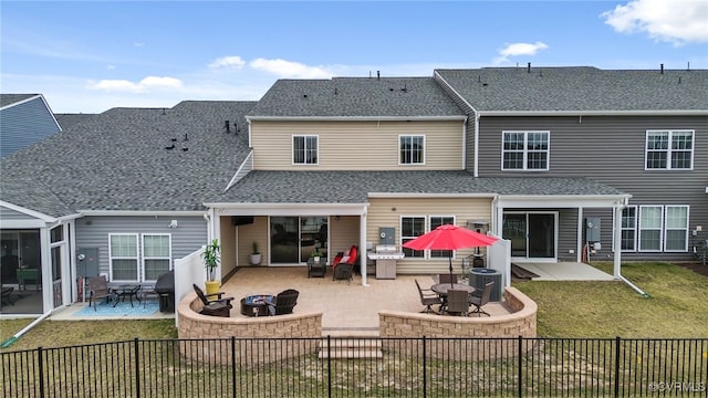 back of property featuring a patio area, a yard, a fire pit, and a fenced backyard