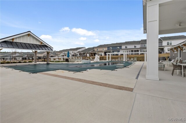 community pool with a residential view and a patio