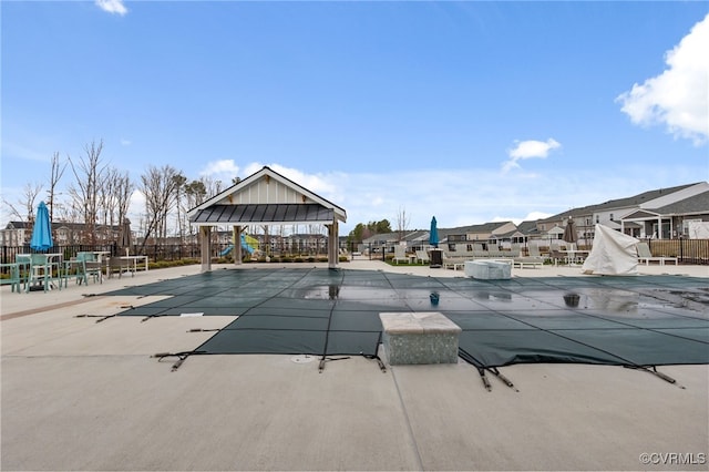 community pool featuring a gazebo, a residential view, a patio, and fence