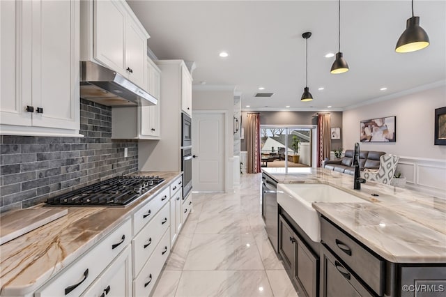 kitchen with decorative backsplash, ornamental molding, under cabinet range hood, and stainless steel appliances