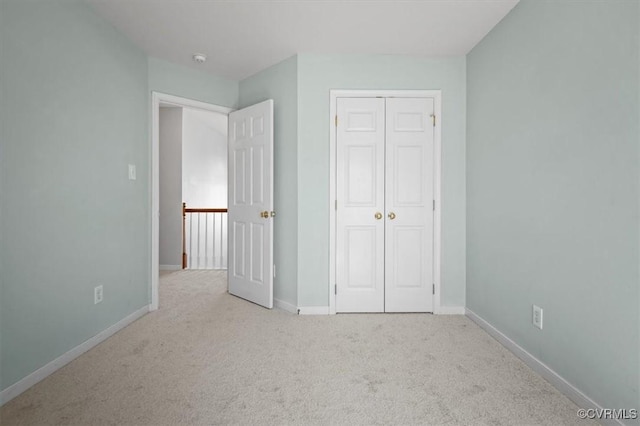 unfurnished bedroom featuring carpet, baseboards, and a closet