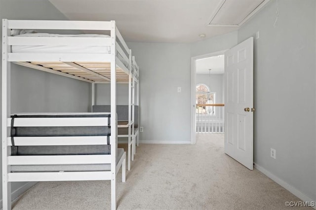 unfurnished bedroom with baseboards, carpet, and attic access