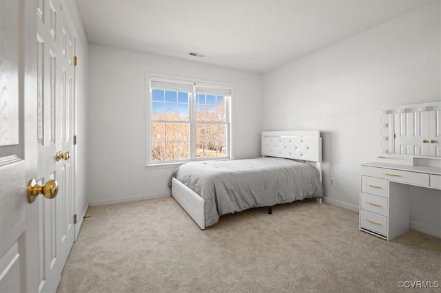 bedroom with visible vents, light colored carpet, and baseboards