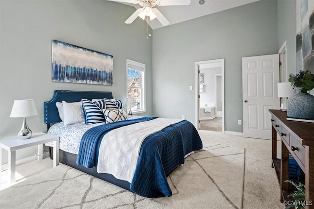 carpeted bedroom featuring ceiling fan, baseboards, and a towering ceiling