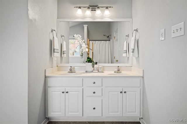 bathroom with double vanity, curtained shower, and a sink