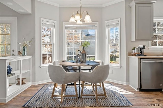 dining area featuring a notable chandelier, wood finished floors, baseboards, and ornamental molding