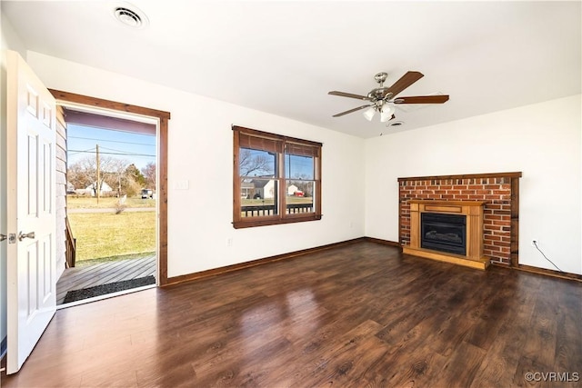 unfurnished living room featuring visible vents, wood finished floors, a fireplace, baseboards, and ceiling fan