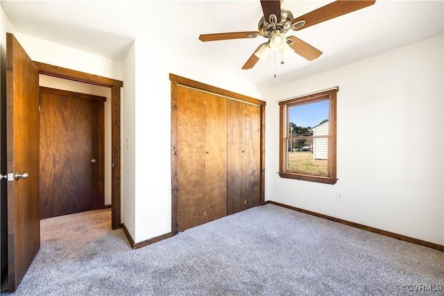 unfurnished bedroom with a closet, baseboards, a ceiling fan, and carpet flooring