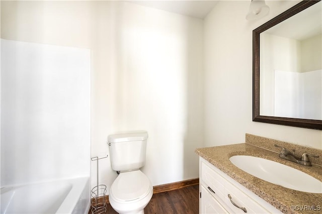 full bathroom with vanity, toilet, wood finished floors, and baseboards