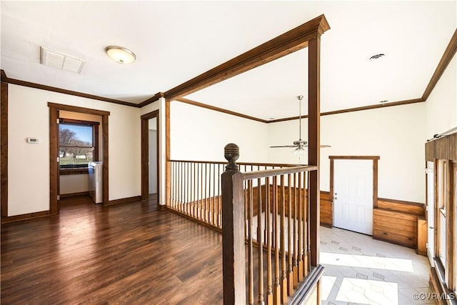 hallway with a wainscoted wall, crown molding, wood finished floors, and visible vents