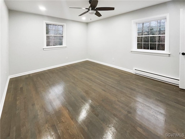 spare room featuring a ceiling fan, a baseboard heating unit, dark wood finished floors, recessed lighting, and baseboards