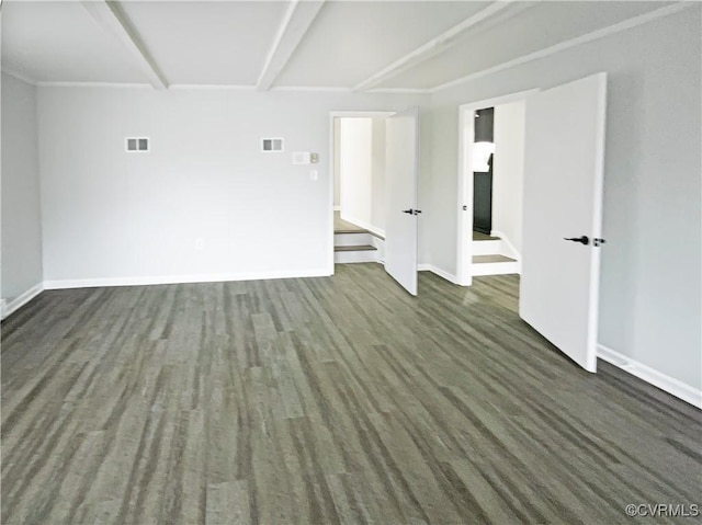 spare room featuring beam ceiling, visible vents, baseboards, and wood finished floors