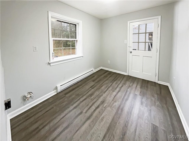 spare room with dark wood finished floors, baseboards, a wealth of natural light, and a baseboard radiator