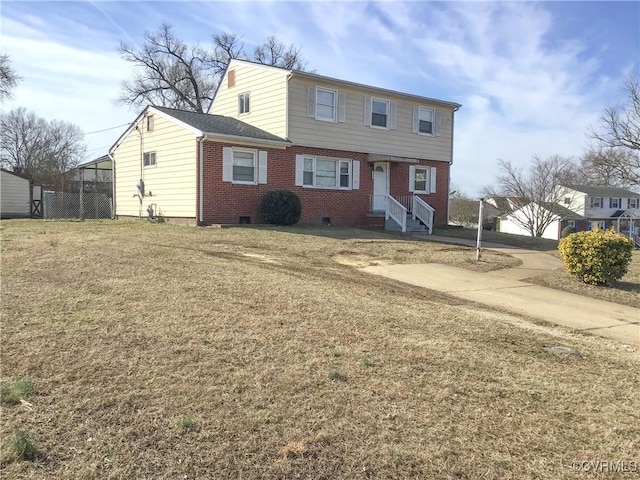 colonial home with crawl space, brick siding, and a front lawn