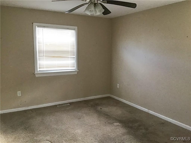 carpeted empty room with a ceiling fan, visible vents, and baseboards