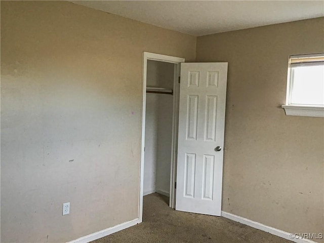 unfurnished bedroom with baseboards, a closet, and carpet floors