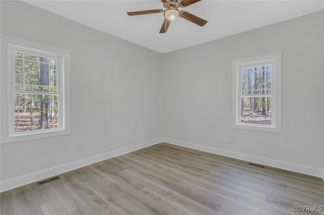 unfurnished room with visible vents, baseboards, and wood finished floors