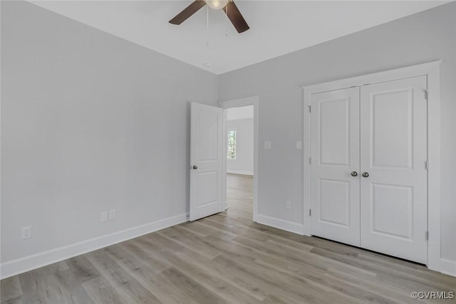 unfurnished bedroom with a closet, baseboards, light wood-style floors, and a ceiling fan