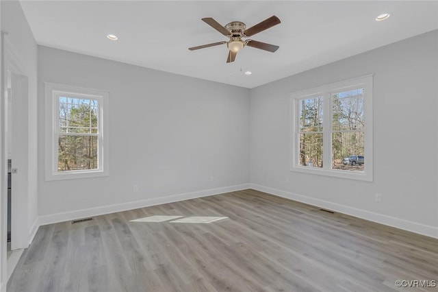 unfurnished room with recessed lighting, light wood-type flooring, and baseboards