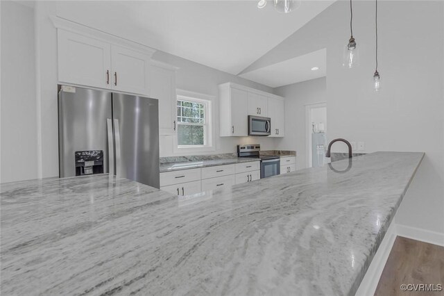 kitchen featuring white cabinetry, lofted ceiling, light stone countertops, and appliances with stainless steel finishes